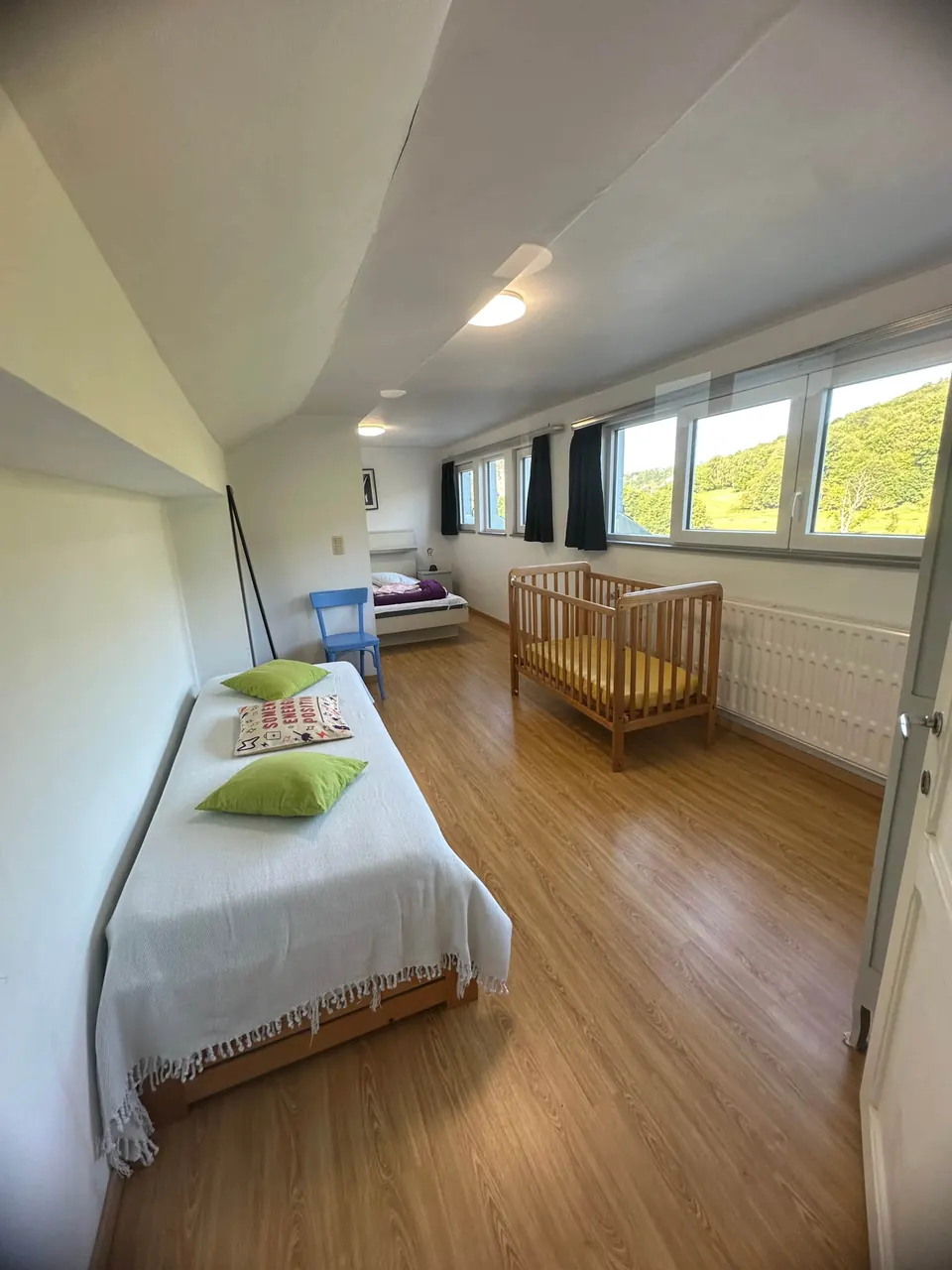 Chambre en longueur avec lit simple et lit bébé