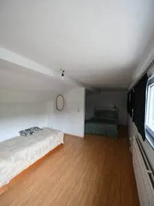 Chambre mansardée avec lit simple