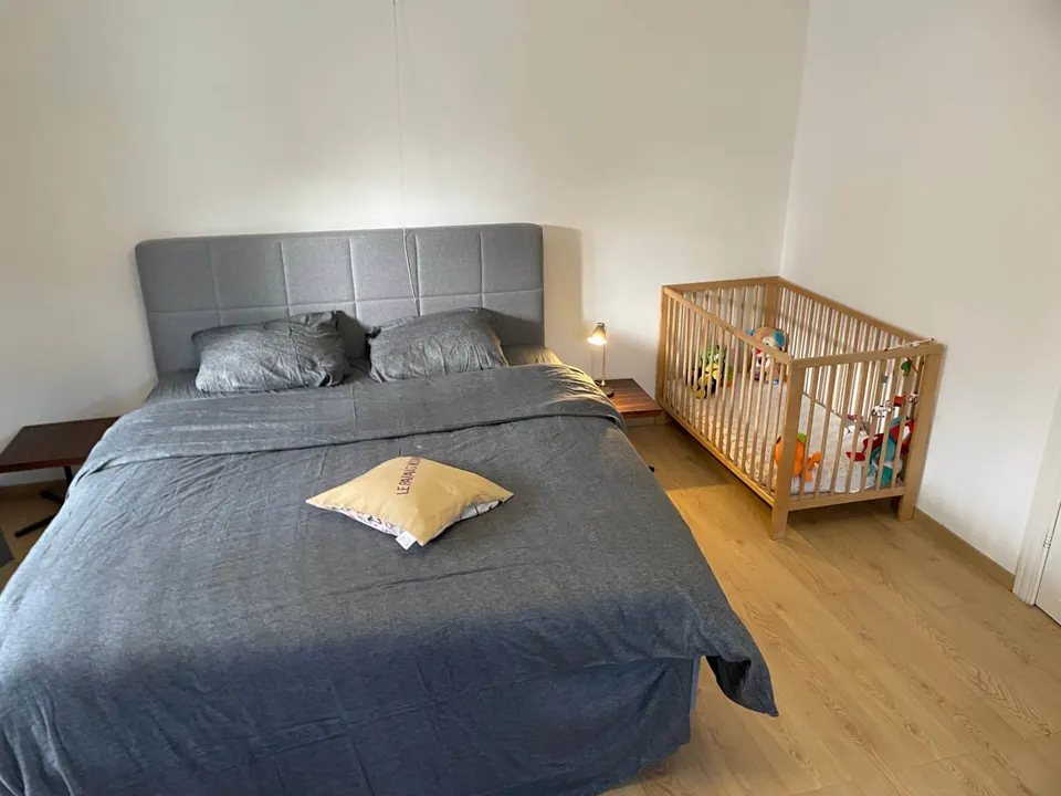 Chambre du rez-de-chaussée avec grand lit double et lit bébé