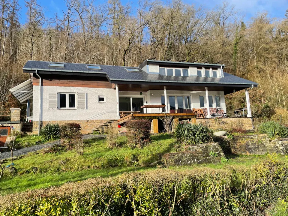 Façade du gîte Le Paradis Mosan et son jardin en terrasses, adossé à la forêt, à Waulsort