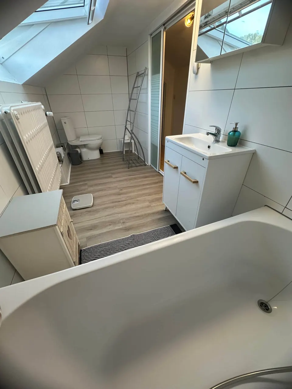 Salle de bain avec baignoire et fenêtre de toit