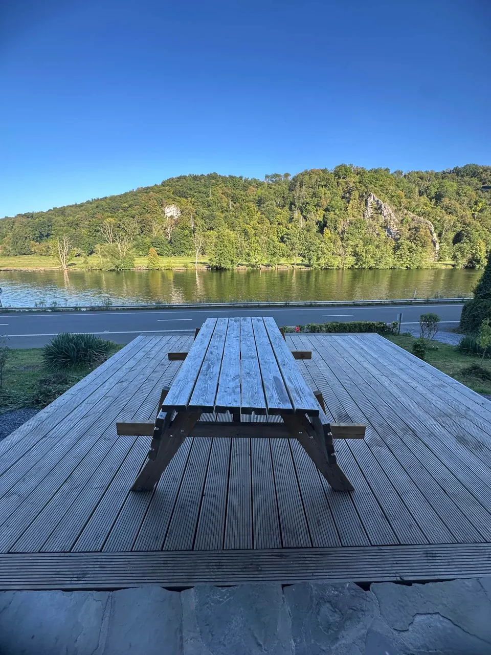 Table de pique-nique sur la terrasse en bois face à la Meuse